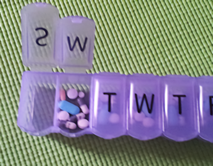 Purple weekly pill organizer open to show Monday's pills