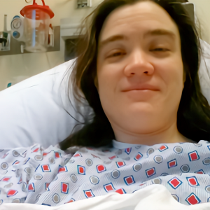 Photo of Christina in a hospital gown with a funny smile on her face after getting morphine